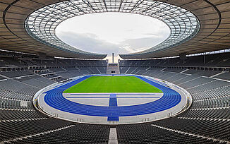Stade olympique de Berlin avec piste bleue emblématique, surnommée « le miracle bleu ». Stade vide destiné aux compétitions nationales et internationales d’athlétisme.